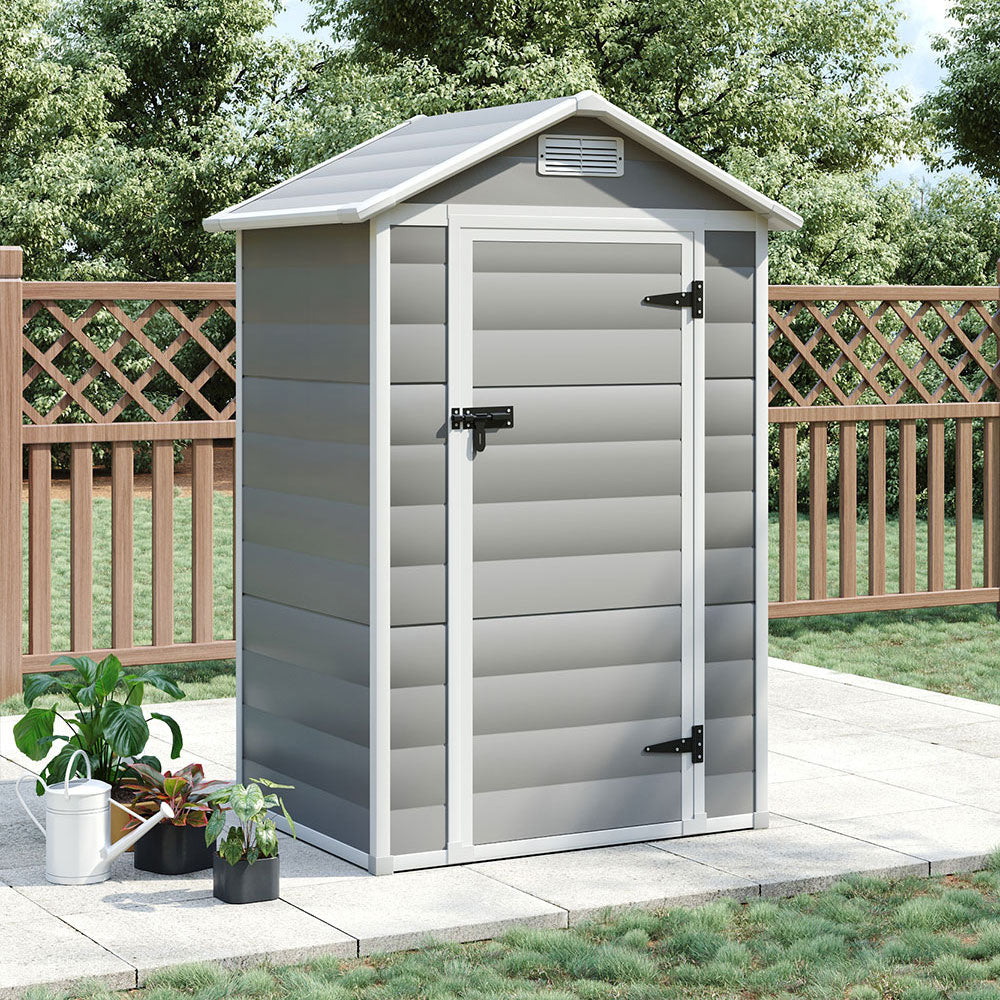 Closed 4x3ft grey plastic tool shed placed on white patio floor against garden fence – neat backyard storage solution