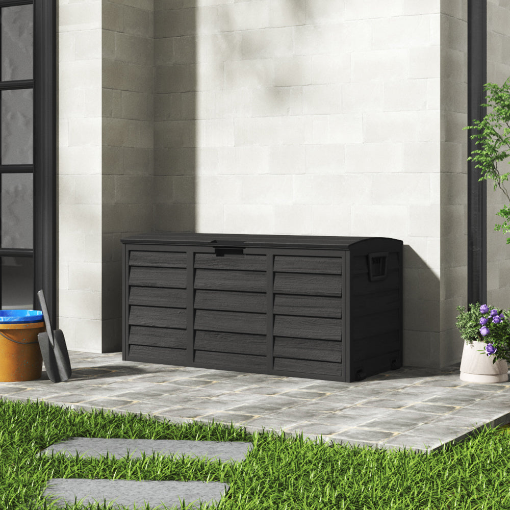 Black 290L outdoor deck box positioned near wall – garden storage for tools, toys, or cushions