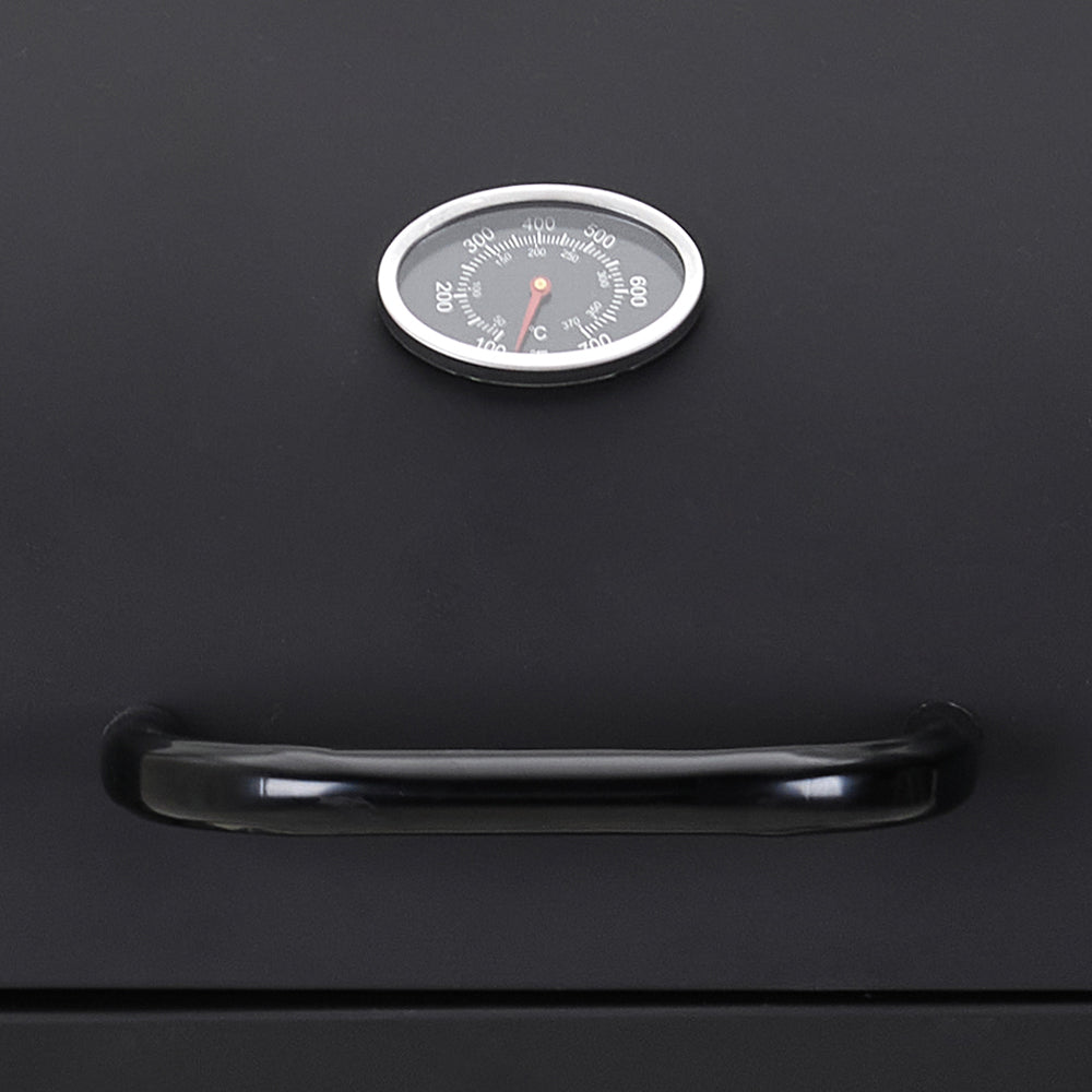 Close-up of side prep panels and temperature gauge on garden charcoal BBQ grill – convenient design for outdoor cooking preparation