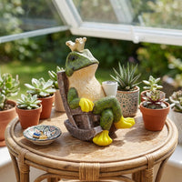 Resin frog prince figurine ornament with crown and mug on a textured stone base