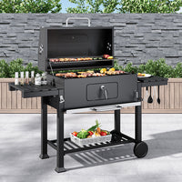 Outdoor charcoal BBQ grill in garden setting – 33x43 inch barrel barbecue with side shelves, perfect for backyard parties