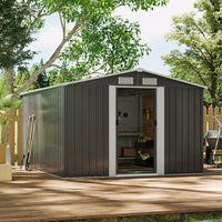 Metal storage shed with open door, surrounded by trees and wooden deck