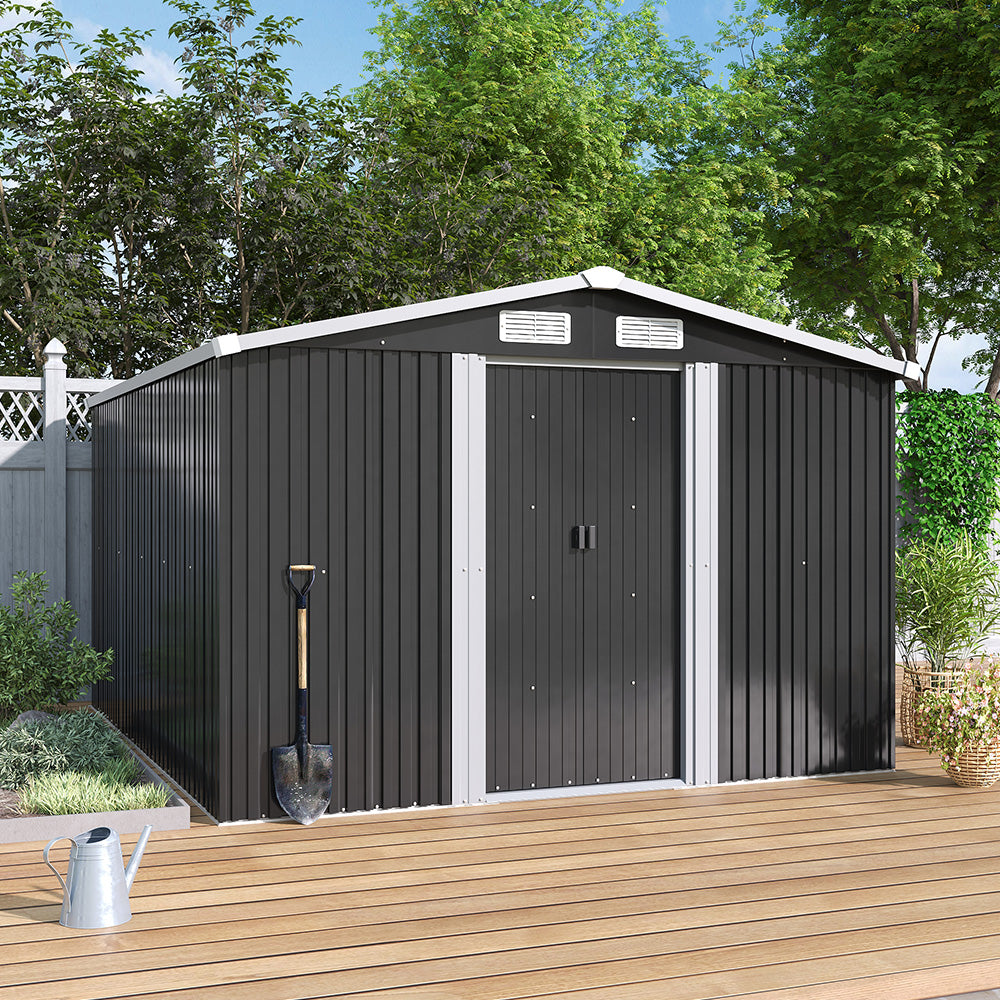 Black metal garden shed with a white door on a wooden deck, surrounded by greenery.
