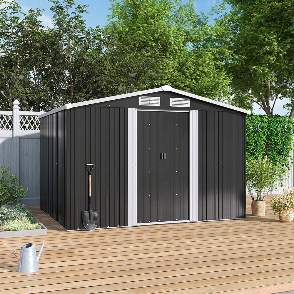 Closed black metal shed on patio floor, placed against wooden garden fence