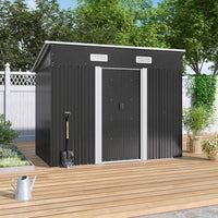closed black garden shed on wooden deck beside backyard fence - patio scene