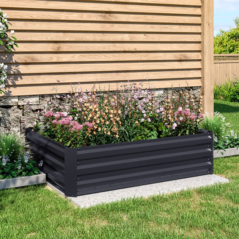 Large Black Galvanized Steel Square Raised Garden Bed in a garden with a variety of flourishing plants