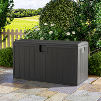 Closed black rattan deck box on patio – outdoor waterproof storage chest for cushions and accessories