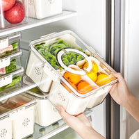 Three-compartment fridge container holding sliced vegetables and eggs in a clear lid